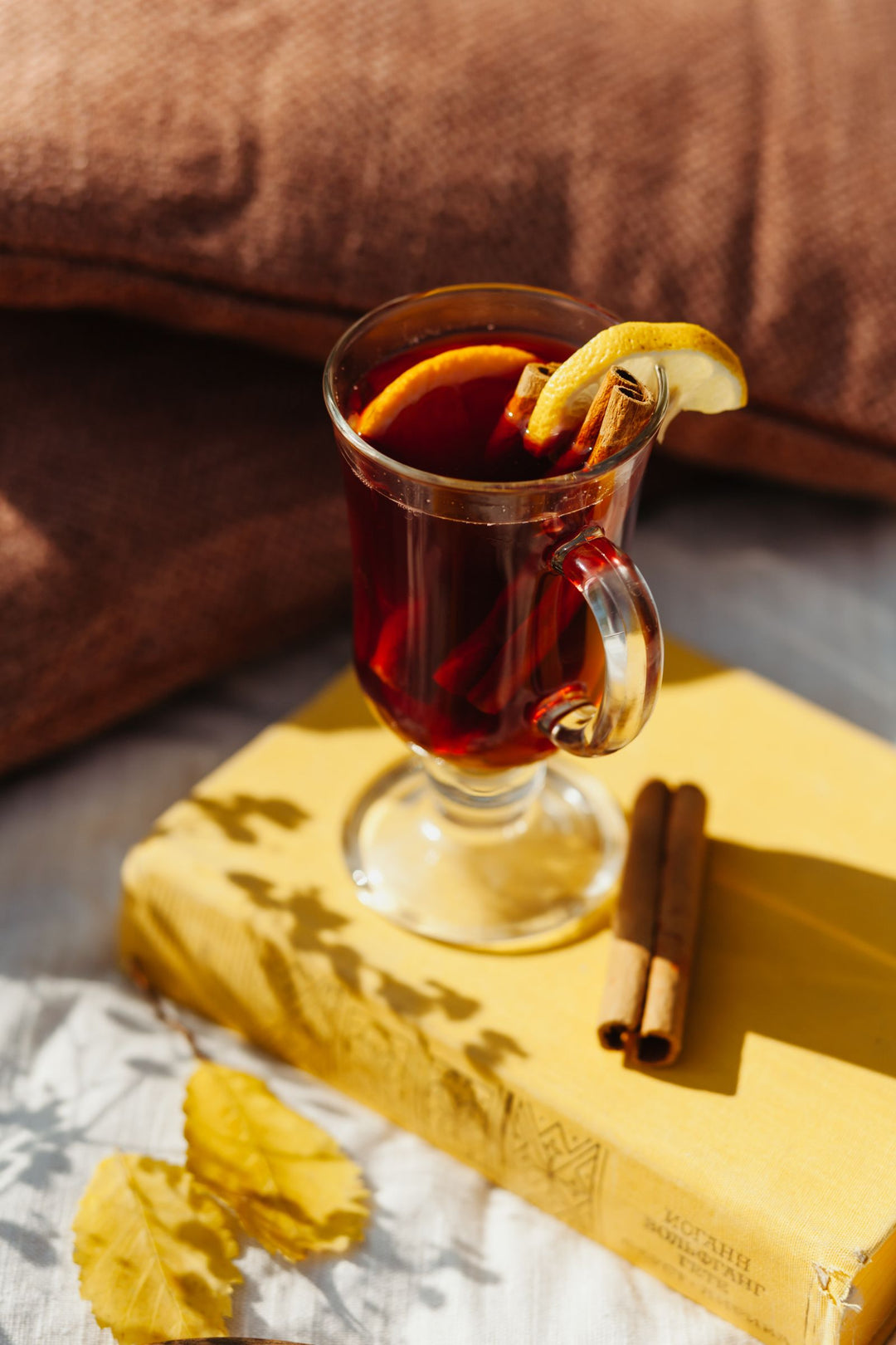 Warm spiced drink in a glass with cinnamon sticks, like a hot buttered rum